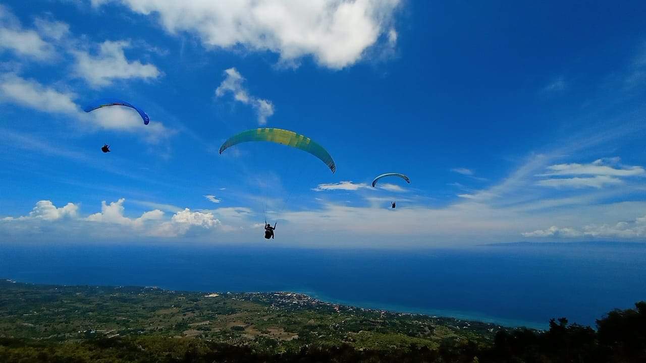 Tandem paragliding flight over Oslob Cebu mountains and coastline